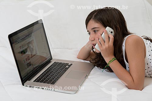  Menina utilizando computador e telefone celular  - Rio de Janeiro - Rio de Janeiro (RJ) - Brasil