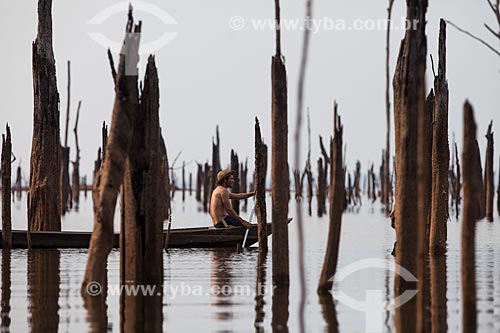  Ribeirinho entre os troncos de árvores que antes estavam submersas pelo lago da Usina Hidrelétrica de Balbina  - Presidente Figueiredo - Amazonas (AM) - Brasil