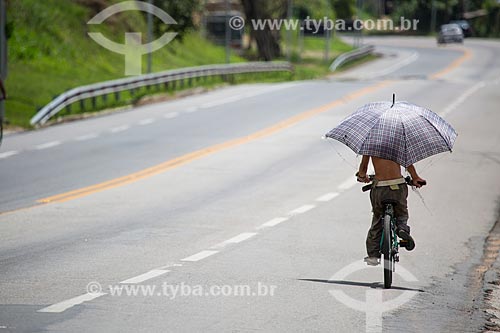  Ciclista com guarda-chuva no acostamento da Rodovia Lucio Meira (BR-393) próximo ao KM-177 - sentido norte  - Três Rios - Rio de Janeiro (RJ) - Brasil