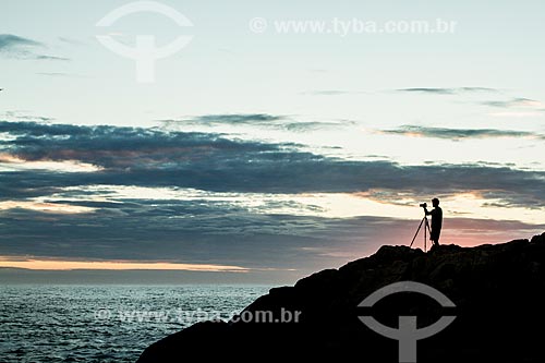  Homem fotografando o costão da Ilha das Campanhas na Praia da Armação do Pântano do Sul durante o amanhecer  - Florianópolis - Santa Catarina (SC) - Brasil