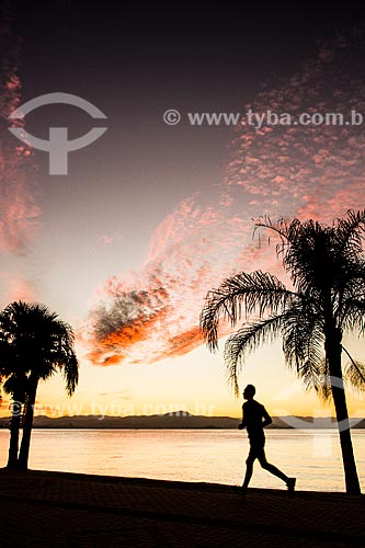  Pessoa correndo no calçadão da Avenida Beira Mar Norte durante o pôr do sol  - Florianópolis - Santa Catarina (SC) - Brasil