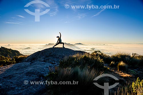  Mulher praticando Yoga - movimento virabhadrasana (guerreiro) - na trilha da Pedra do Sino no Parque Nacional da Serra dos Órgãos  - Teresópolis - Rio de Janeiro (RJ) - Brasil
