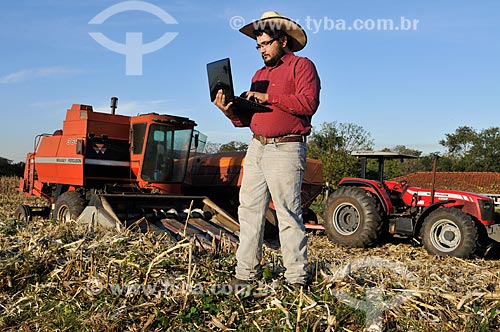  Agricultor com laptop durante a colheita mecanizada de milho  - Mirassol - São Paulo (SP) - Brasil