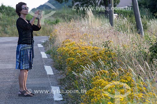  Turista fotografando flores no Parc Naturel Régional du Luberon (Parque Natural Regional do Luberon)  - Apt - Departamento de Vaucluse - França