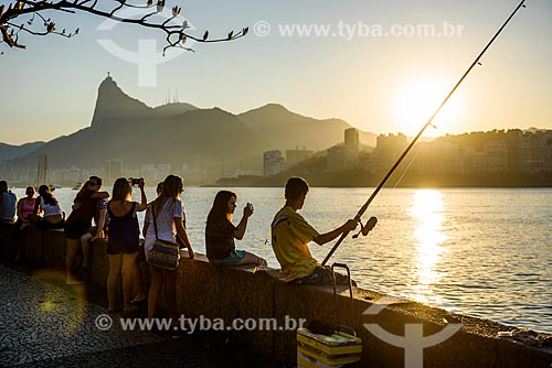  Pessoas observando o pôr do sol e pescando na Mureta da Urca com o Cristo Redentor ao fundo  - Rio de Janeiro - Rio de Janeiro (RJ) - Brasil