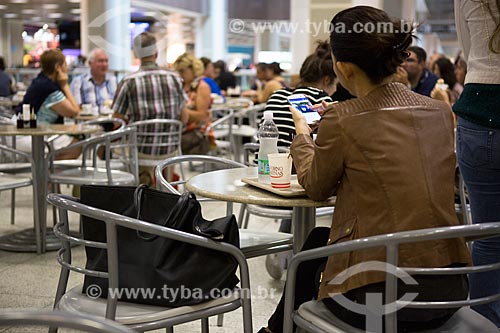  Mulher com telefone celular na praça de alimentação do Aeroporto Santos Dumont  - Rio de Janeiro - Rio de Janeiro (RJ) - Brasil