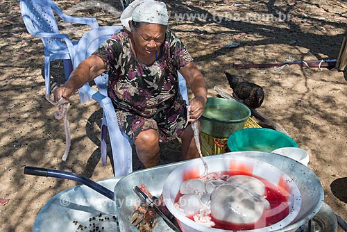  Mulher idosa limpando partes de bode na Aldeia Travessão de Ouro - Tribo Pipipãs  - Floresta - Pernambuco (PE) - Brasil