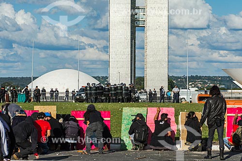  Manifestantes se protegendo do confronto com a Polícia Militar durante a manifestação contra o governo de Michel Temer na Esplanada dos Ministérios  - Brasília - Distrito Federal (DF) - Brasil
