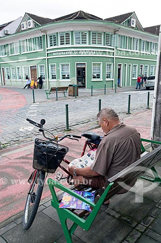  Homem lendo jornal na Rua Luiz Abry com o Restaurante Schroeder ao fundo  - Pomerode - Santa Catarina (SC) - Brasil