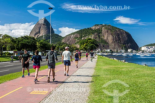  Pessoas caminhando na ciclovia da Praia de Botafogo com o Pão de Açúcar ao fundo  - Rio de Janeiro - Rio de Janeiro (RJ) - Brasil