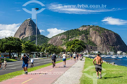  Pessoas caminhando na ciclovia da Praia de Botafogo com o Pão de Açúcar ao fundo  - Rio de Janeiro - Rio de Janeiro (RJ) - Brasil