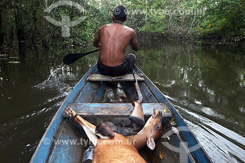  Ribeirinho levando em sua canoa veado caçado na floresta amazônica  - Amazonas (AM) - Brasil