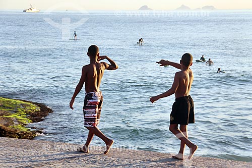  Meninos andando no calçadão da Praia do Arpoador  - Rio de Janeiro - Rio de Janeiro (RJ) - Brasil