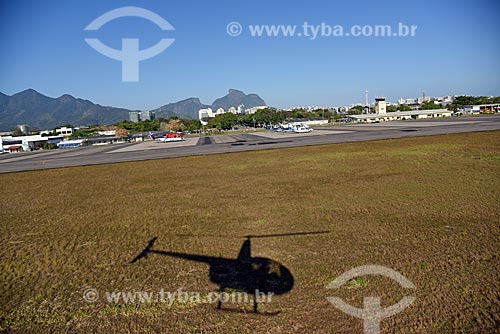  Sombra de helicóptero no Aeroporto Roberto Marinho - mais conhecido como Aeroporto de Jacarepaguá - com a Pedra da Gávea ao fundo  - Rio de Janeiro - Rio de Janeiro (RJ) - Brasil