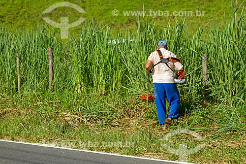  Homem podando grama acostamento do Rodovia MG-353 entre as cidades de Guarani e Pirauba  - Guarani - Minas Gerais (MG) - Brasil