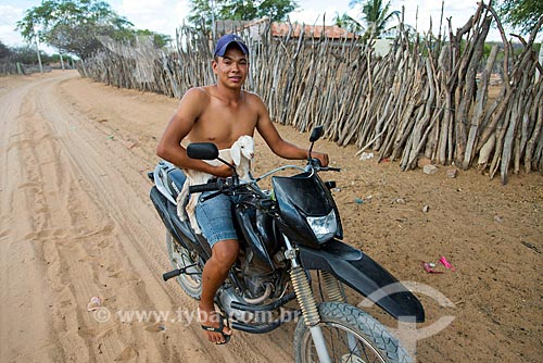  Índio da aldeia Travessão do Ouro da Tribo Pipipãs carregando bezerro em moto  - Floresta - Pernambuco (PE) - Brasil
