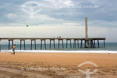  Jovem jogando futebol na orla da Praia de Costazul com o Emissário submarino ao fundo  - Rio das Ostras - Rio de Janeiro (RJ) - Brasil