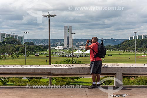  Homem fotografando o centro de Brasília com o Congresso Nacional ao fundo  - Brasília - Distrito Federal (DF) - Brasil