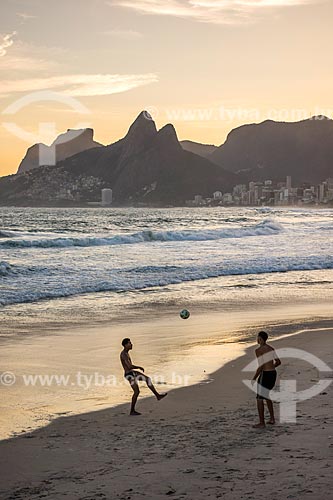  Banhistas jogando futebol (altinha) na orla da Praia de Ipanema durante o pôr do sol com a Pedra da Gávea e o Morro Dois Irmãos ao fundo  - Rio de Janeiro - Rio de Janeiro (RJ) - Brasil