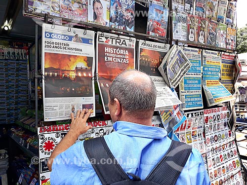  Homem lendo jornais expostos na banca de jornal após o incêndio de grandes proporções que destruiu quase a totalidade do acervo histórico  - Rio de Janeiro - Rio de Janeiro (RJ) - Brasil
