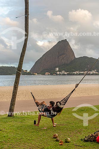  Casal deitado em uma rede na orla da Praia do Flamengo com o Pão de Açúcar ao fundo  - Rio de Janeiro - Rio de Janeiro (RJ) - Brasil