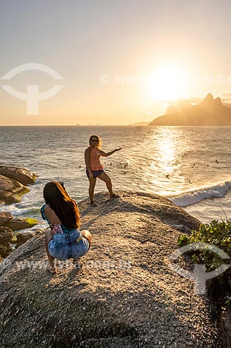  Mulher fazendo uma fotografia em perspectiva forçada durante o pôr do sol na Pedra do Arpoador  - Rio de Janeiro - Rio de Janeiro (RJ) - Brasil
