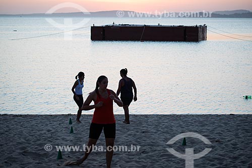  Silhueta de mulheres praticando treino funcional na orla da Lagoa de Araçatiba durante o pôr do sol  - Maricá - Rio de Janeiro (RJ) - Brasil