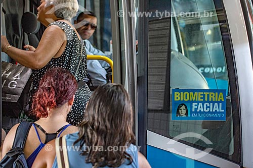  Passageiros embarcando em ônibus na Rodoviária do Povo de Maricá - antigo Terminal Rodoviário Jacinto Luis Caetano - com adesivo informando a utilização de sistema de Biometria Facial  - Maricá - Rio de Janeiro (RJ) - Brasil