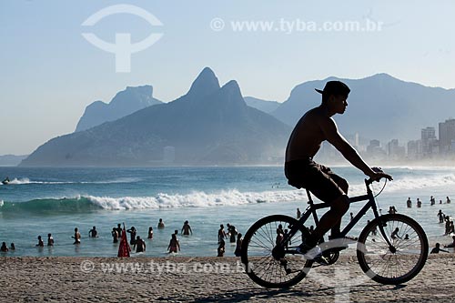  Ciclista na orla da Praia do Arpoador com o Morro Dois Irmãos e a Pedra da Gávea ao fundo  - Rio de Janeiro - Rio de Janeiro (RJ) - Brasil