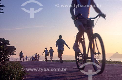  Ciclista e pedestres na ciclovia do Aterro do Flamengo durante o pôr do sol - década de 2000  - Rio de Janeiro - Rio de Janeiro (RJ) - Brasil