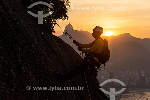  Alpinista durante a escalada no Morro da Urca durante o pôr do sol com o Cristo Redentor ao fundo  - Rio de Janeiro - Rio de Janeiro (RJ) - Brasil