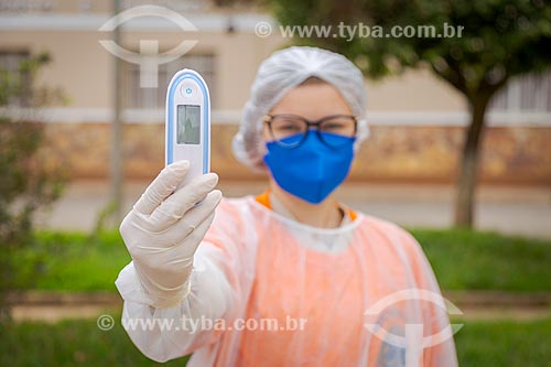  Enfermeira segurando termômetro - Profissionais da área da saúde pública realizam controle sanitário na entrada da cidade de Guarani - Crise do Coronavírus  - Guarani - Minas Gerais (MG) - Brasil