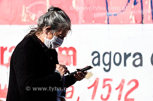  Mulher usando máscara de proteção na rua enquanto utiliza telefone celular - Crise do Coronavírus  - Porto Alegre - Rio Grande do Sul (RS) - Brasil