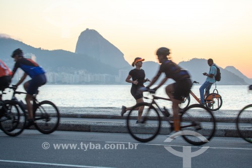 Ciclistas na Avenida Atlântica ao nascer do sol - Pão de Açúcar ao fundo - Rio de Janeiro - Rio de Janeiro (RJ) - Brasil