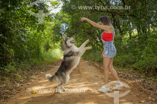 Mulher passeia com cachorro da raça Husky Siberiano em estrada rural - Guarani - Minas Gerais (MG) - Brasil
