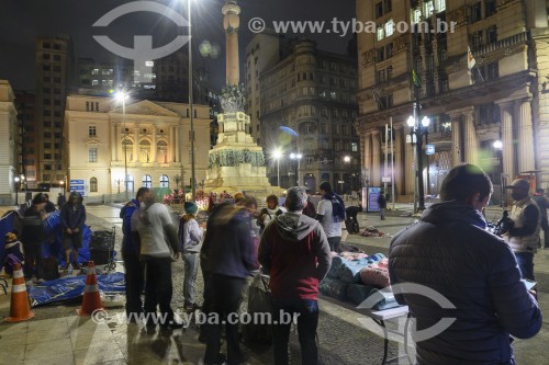 Voluntários entregando comida e cobertores para moradores de rua dormindo no Pátio do Colégio (1554), marco da fundação da cidade de São Paulo, no dia mais frio do ano - São Paulo - São Paulo (SP) - Brasil