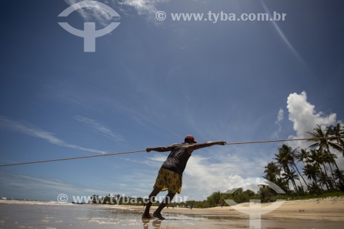 Pescador recolhendo rede de pesca na Praia do Riacho - Prado - Bahia (BA) - Brasil