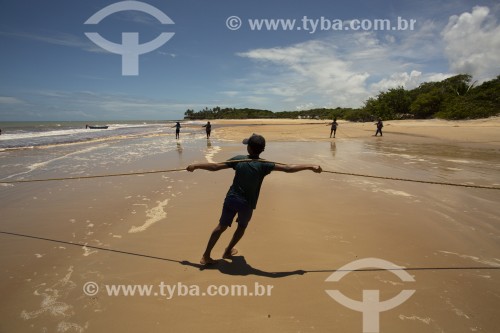 Pescador recolhendo rede de pesca na Praia do Riacho - Prado - Bahia (BA) - Brasil