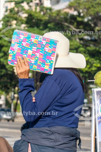 Pessoa protegendo o rosto com caderno para não ser fotografada - Rio de Janeiro - Rio de Janeiro (RJ) - Brasil