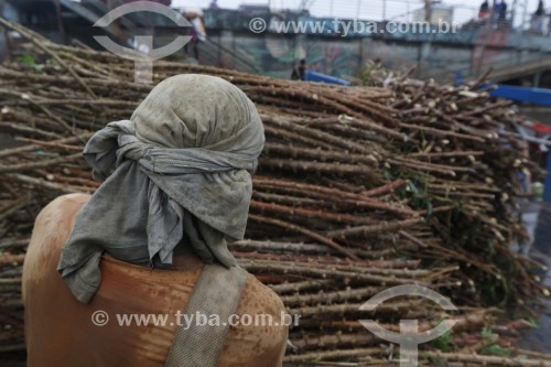 Trabalhador carregando mudas de mandioca (maniva) no Porto da Manaus - Manaus - Amazonas (AM) - Brasil