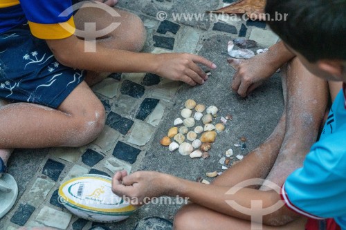 Crianças brincando com conchas do mar durante a Alvorada Festiva - comemoração do centenário da Colônia de pescadores Z-13 - no Posto 6 da Praia de Copacabana - Rio de Janeiro - Rio de Janeiro (RJ) - Brasil