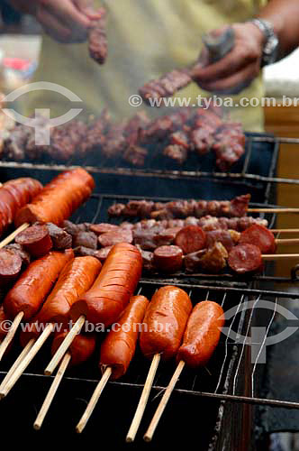  Man preparing barbecue (detail of the hands) - sausages  - Rio de Janeiro city - Brazil