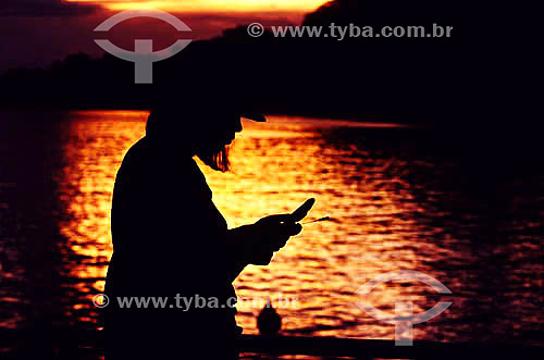  Silhouette of a woman holding a cellular phone 