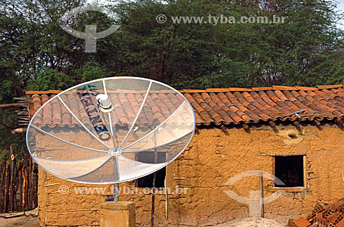  House - house made of wattle and daub with a satellite dish in front of it - Areia Branca - Mossoro - Rio Grande do Norte state - Brazil - May 2001 