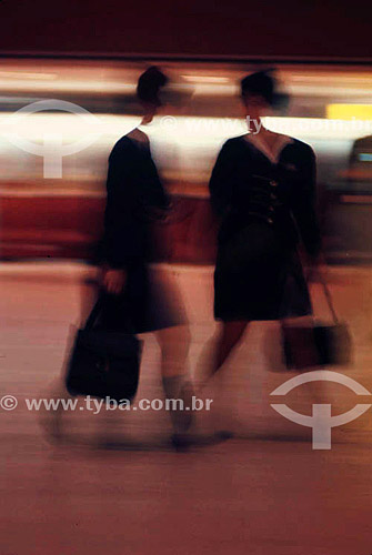  Stewardesses - Female flight attendants walking, carrying small suitcases 