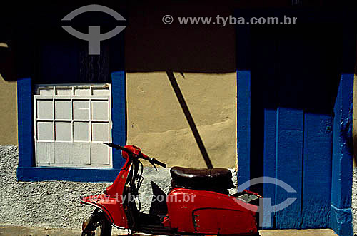  Red motorbike parked in front of a house 