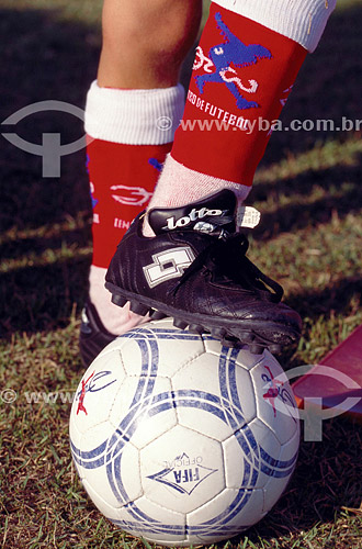  Detail of the leg of the football player with the football boots and the ball. 