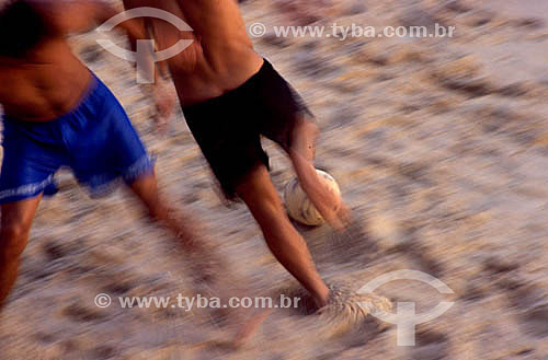  Boys playing soccer game on the beach - Brazil 