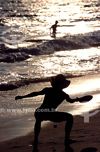  Leisure - silhouette of woman playing Frescobol (kind of racketball played mainly on the beach) 