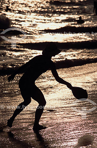  Leisure - silhouette of woman playing Frescobol (kind of racketball played mainly on the beach) 